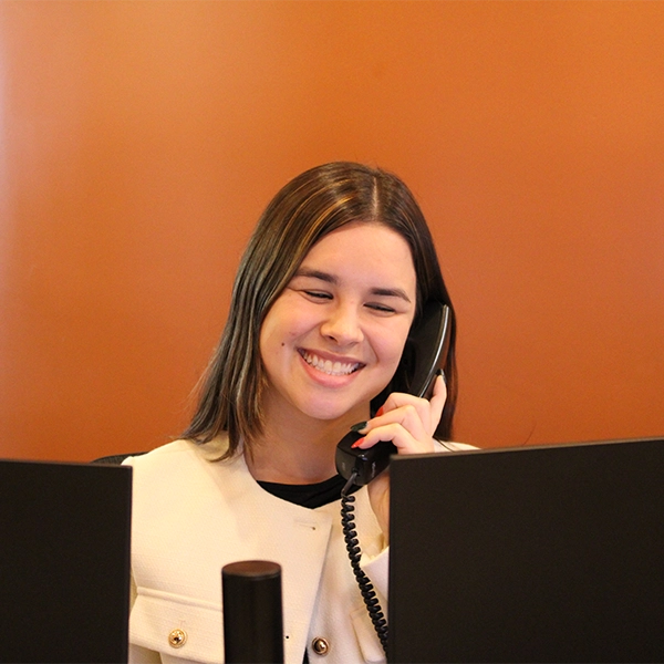Staff member Ceci Falkenstein answering a call at the front desk