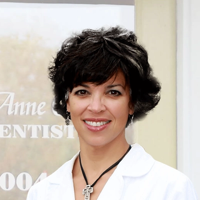 Dentist Martha Anne Carr Smiling Outdoors In Front Of Office Door